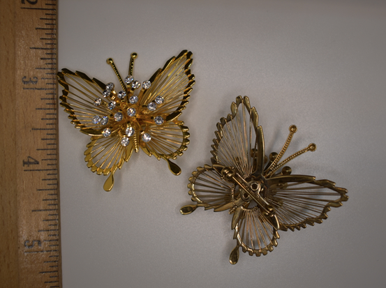 Two 1980's vintage gold tone butterfly brooches with rhinestone center