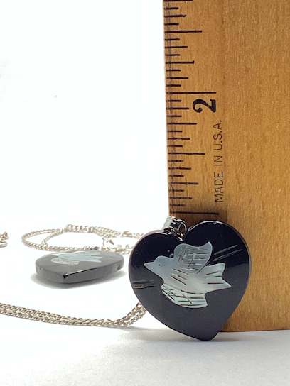 Two 1970's-90's vintage black heart with white bird pendants on silver chains
