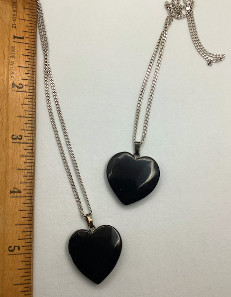 Two 1970's-90's vintage black heart with white bird pendants on silver chains